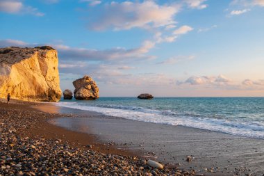 Öğleden sonra güzel manzarasına beach çevresinde Petra tou Romiou, Paphos, Kıbrıs bir çocukla uzaktan geziniyor. Yunan mitolojisinde Afrodit'ın Doğum yeri olarak kabul edilir.
