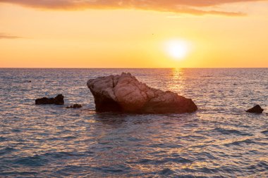 Beach çevresinde Petra tou Romiou, Paphos, Kıbrıs için güzel gün batımı manzarası. Yunan mitolojisinde Afrodit'ın Doğum yeri olarak kabul edilir.