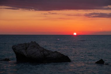Beach çevresinde Petra tou Romiou, Paphos, Kıbrıs için güzel gün batımı manzarası. Yunan mitolojisinde Afrodit'ın Doğum yeri olarak kabul edilir.
