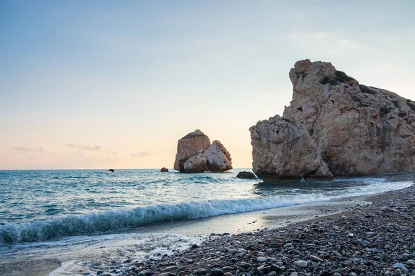 Petra tou Romiou, Paphos, Kıbrıs için çevresinde çakıllı plaj dalgalar breaking öğleden sonra Görünüm. Yunan mitolojisinde Afrodit'ın Doğum yeri olarak kabul edilir.