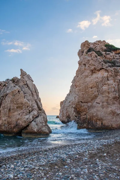 Petra tou Romiou, Paphos, Kıbrıs için çevresinde çakıllı plaj dalgalar breaking öğleden sonra Görünüm. Yunan mitolojisinde Afrodit'ın Doğum yeri olarak kabul edilir.