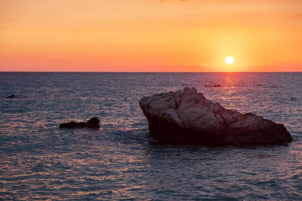 Beach çevresinde Petra tou Romiou, Paphos, Kıbrıs için güzel gün batımı manzarası. Yunan mitolojisinde Afrodit'ın Doğum yeri olarak kabul edilir.
