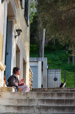 Bir hipster kız bir evin merdivenlerinde oturan davul çalar 