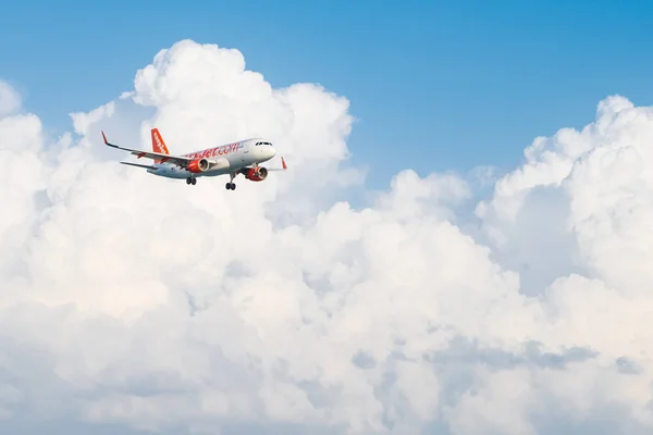 Easyjet Airbus A320 che vola in nuvole bianche e cielo blu, terra — Foto Stock