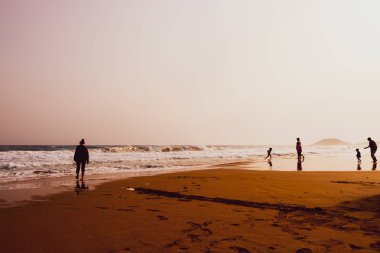 Kumlu Golden Beach, Karpasia, C oynayan insanların siluetleri