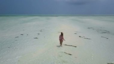 Hava: elbise kız yalnız Cennet plaj yürüyor. Jambiani Beach