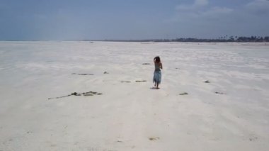 Hava: elbise kız yalnız Cennet plaj yürüyor. Jambiani Beach