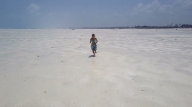 Hava: elbise kız yalnız Cennet plaj yürüyor. Jambiani Beach