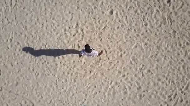 Aerial: African man dancing in a palm grove on the beach — Stock Video