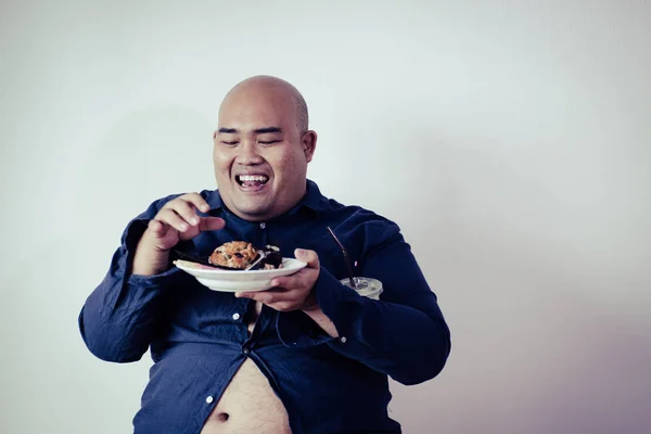 fat man eating, portrait of overweight person feels hungry and eating chips,cake,green tea frappe seated on armchai, isolated on white background with clipping path