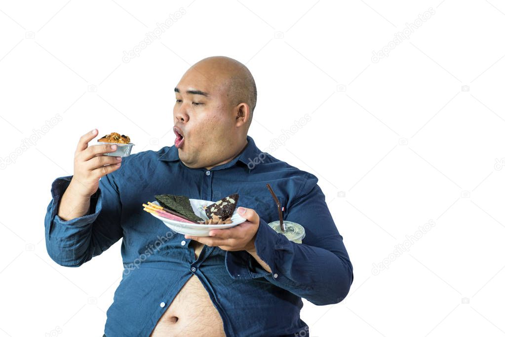 fat man eating, portrait of overweight person feels hungry and eating chips,cake,green tea frappe seated on armchai, isolated on white background with clipping path