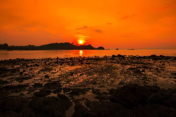 Bir kayalık sahil ve deniz güzel gün batımını sabah görüntülemek.