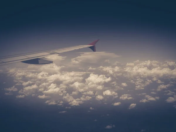 View from the airplane window, wing of airplane flying above the clouds in the sky — Stock Photo, Image