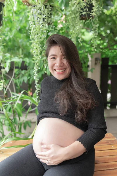 Mujer embarazada sintiéndose feliz en casa mientras cuida de su hijo. Atención prenatal de maternidad y concepto de embarazo de la mujer . —  Fotos de Stock