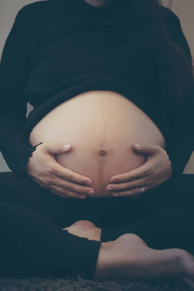 Femme enceinte se sentant heureuse à la maison tout en prenant soin de son enfant. Soins prénatals de maternité et concept de grossesse chez la femme . — Photo