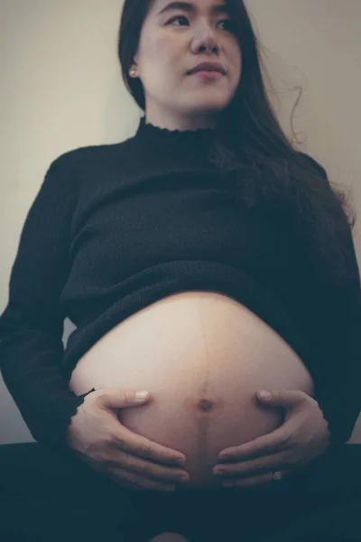 Zwangere vrouw die zich gelukkig voelt terwijl ze voor haar kind zorgt. Zwangerschap prenatale zorg en vrouw zwangerschap concept. — Stockfoto