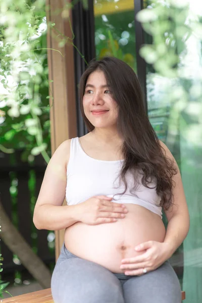 Mulher grávida sentindo-se feliz em casa enquanto cuida de seu filho. Conceito de pré-natal maternidade e gravidez da mulher . — Fotografia de Stock