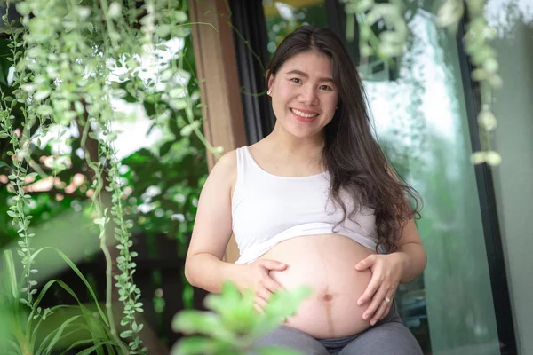 Mulher grávida sentindo-se feliz em casa enquanto cuida de seu filho. Conceito de pré-natal maternidade e gravidez da mulher . — Fotografia de Stock