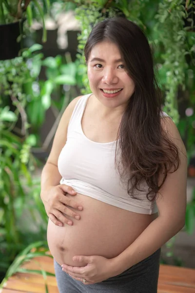 Mujer embarazada sintiéndose feliz en casa mientras cuida de su hijo. Atención prenatal de maternidad y concepto de embarazo de la mujer . —  Fotos de Stock