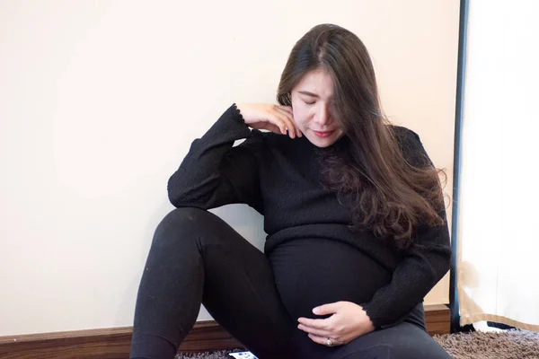 A terhes nő otthon érzi magát, miközben vigyáz a gyerekére. Terhesség Terhesség és terhesség fogalma. — Stock Fotó