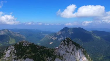 Tegernsee Htte 'nin 4K hava aracı videosu. Güneşli bir günde Leonhardstein' ı çevreleyen Alman Alpleri 'ndeki Rostein ve Buchstein tepeleri arasındaki dağlarda yuva yapmış inanılmaz bir kulübe.