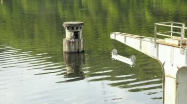 Büyük metal vinç. Kanca, raylar ve makaralar, su yüzeyinin arka planda. Su dev beton baraj, hidroelektrik powerstation. Baraj görünümünden su drenaj, gün atış