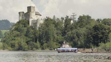 Ortaçağ Kalesi Gölü yukarıda tepede. Göl feribot, turist tekne ile. Anıtsal taş ile büyük kulesi inşa tarihi. Yaz tatil sahne bulutlu. Olumlu ruh, güzel manzara