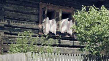 Yastık ile açık eski pencere. Battaniye uyku dışında havalandırma. Dağ Vadisi Ortaçağ ahşap köy. Güzel yaz sahne tatil