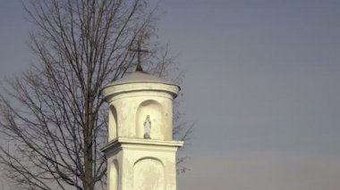 İsa ile Meryem Ana heykeli. Küçük Hıristiyan haç heykel, mavi gökyüzü ve ağaç arka planda, güzel Avrupa kırsal mimari ile. Köy çarmıha calvary Barok tarzı. Pastoral güneşli huzurlu ortam