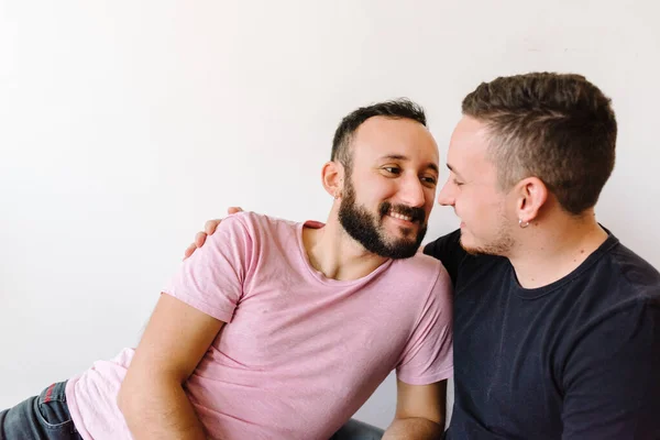 アパートで楽しそうに笑っている2人の白人同性愛者の男性のストックフォト 彼らの一人は背後からもう一人を抱き上げている — ストック写真
