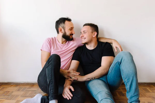 2人の白人同性愛者の男性のストックフォト彼らのアパートで幸せ 彼らの一人は背後からもう一人を抱き上げている — ストック写真