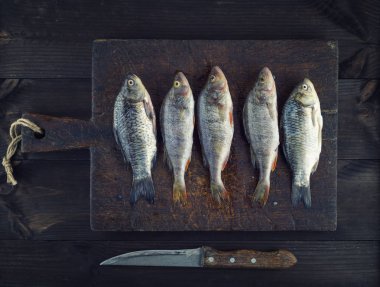ölçekler yalan üzerine kahverengi ahşap masa, üstten görünüm üzerinden temizlenmiş taze balık levrek ve sazan 