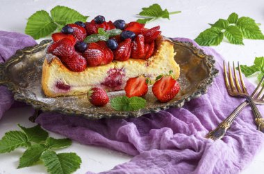 süzme peynir ve bir plaka üzerinde taze çilek cheesecake taze çilek ve yaban mersini ile dekore edilmiş