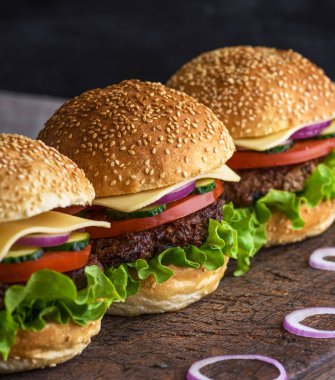 Sığır eti, peynir ve sebze closeup rustik kahverengi masada hamburger