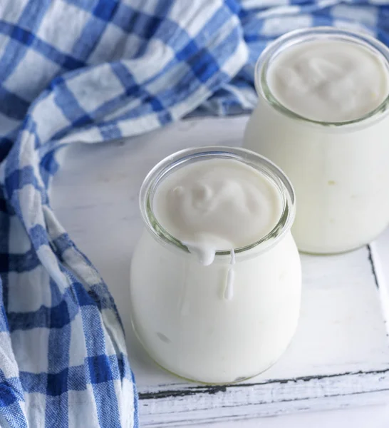 Glazen Potten Met Zelfgemaakte Yoghurt Een Witte Houten Bord Bovenaanzicht — Stockfoto