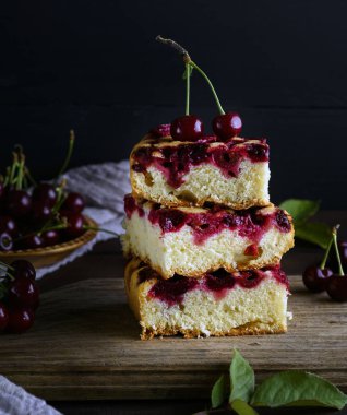 dilim börek kahverengi ahşap masa, siyah arka plan üzerinde taze kiraz üzerinden yığını