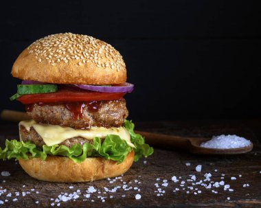 çizburger ile susam çörek, orta taze sebze ve et pirzola, siyah arka plan