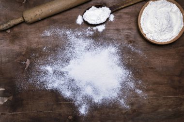 beyaz buğday unu dağınık bir kahverengi ahşap yüzey, üstten görünüm