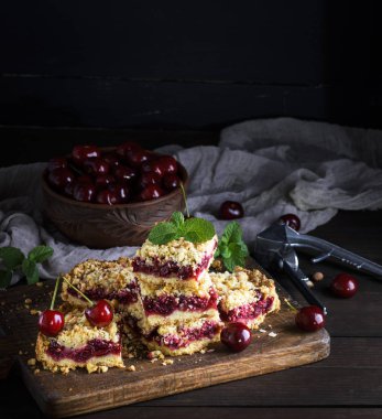 kiraz ve seramik kase taze çilek, siyah arka plan ile pişmiş kek yığını