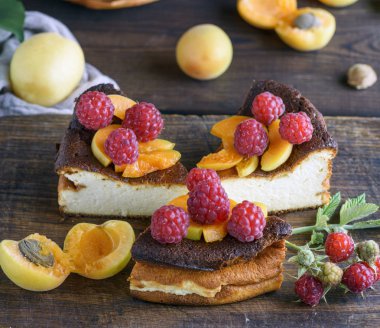 çilek ve kayısı kahverengi ahşap tahta üzerinde süzme peynir pasta parçalarını yakın çekim