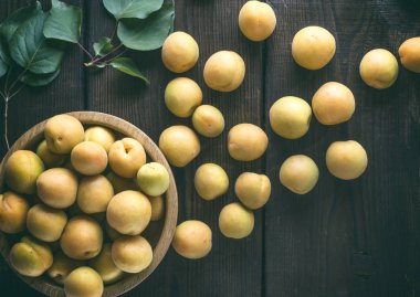 Olgun kayısı dağınık bir kahverengi ahşap masa, vintage tonlama, üstten görünüm üzerinde