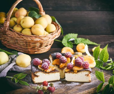 süzme peynir pasta çilek ve kayısı kahverengi ahşap tahtası, üstten görünüm ile parçaları