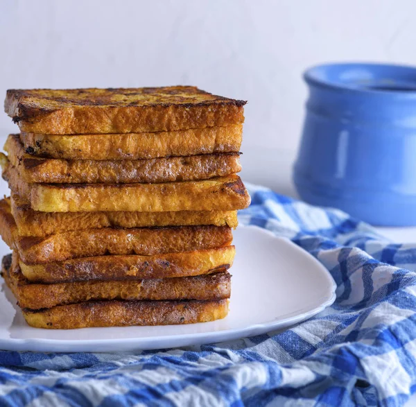 Beyaz seramik tabakta kızarmış beyaz ekmek parçaları, Fransız tostu.