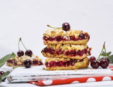 Beyaz ahşap tahta, beyaz arka plan üzerinde kiraz çilek ile bir pasta fırında grafiğin dilimlerini bir yığın