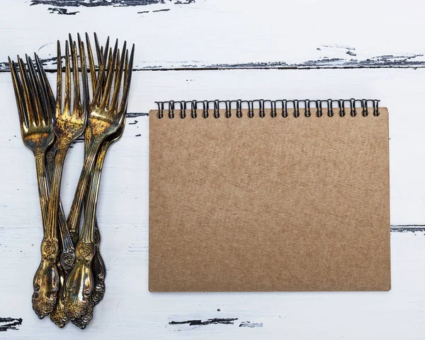 Cuaderno Abierto Con Páginas Vacías Marrones Una Pila Tenedores Metal — Foto de Stock
