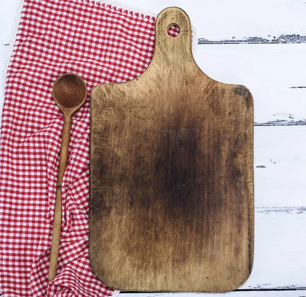 empty brown old kitchen cutting board and wooden spoon on white table, copy space