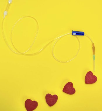 Plastik sonda ile sarı zemin üzerine iğne ve kırmızı kalp
