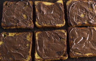 kare kızartılmış beyaz ekmek parçalarını çikolata kahverengi ahşap tahtası ile bulaşmış