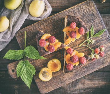 süzme peynir pasta çilek ve kayısı kahverengi ahşap tahtası, üstten görünüm ile parçaları