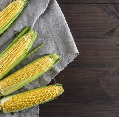 taze olgun Mısır koçanı bir gri kumaş peçete, ahşap arka plan, sağdaki boş alanı